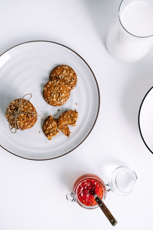 Oatmeal cookies with a carafe of milk on a white plate. High quality photoの写真素材