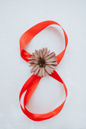 Festive red ribbon on a white background in the form of a figure eight. Women's day concept.