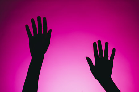 Silhouette of female hands isolated on a pink background. Abstraction.の写真素材