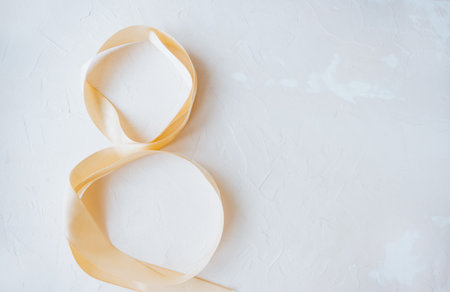 Festive ribbon on a white background in the form of a figure eight. Women's day concept.