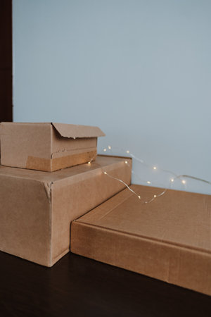 Cardboard boxes on a wooden table with garland.