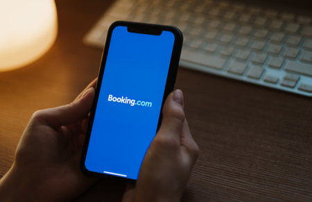 Woman use booking app, booking com logo on the smartphone screen. High quality photoのeditorial素材