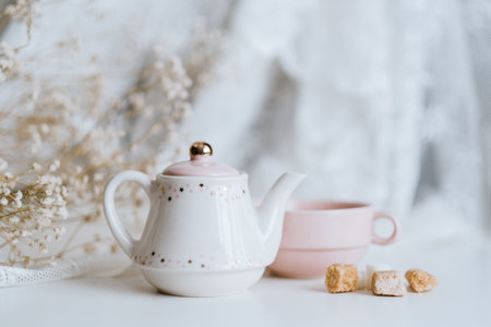 Tea set, teapot with sugar cubes and a cup with brewed tea on a white pastel background. High quality photo.の写真素材