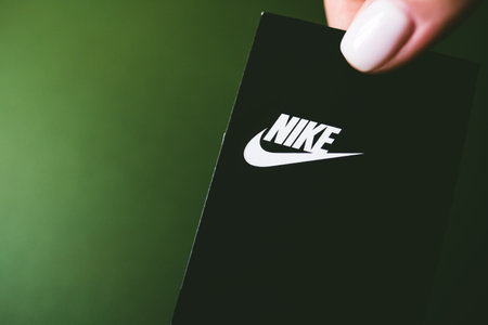 Closeup of Nike logo label on green background. Nike logo. Nike is a global sports clothes.のeditorial素材