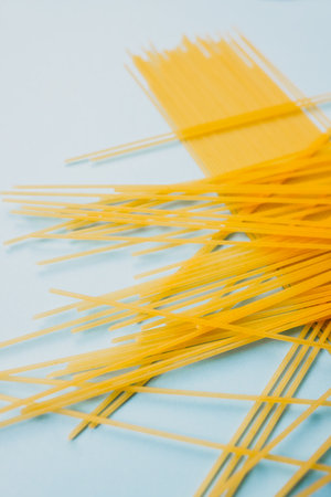 Wheat pasta spaghetti isolated on a blue background. Top view.の写真素材