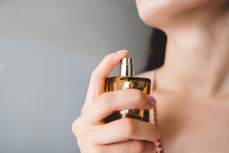 Woman puts on perfume on a gray background.Top view.の写真素材