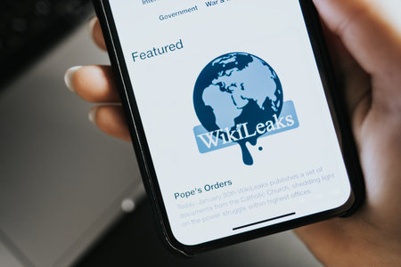 hands holding iPhone X with Wikileaks logo site home page on the screen. High quality photo.のeditorial素材