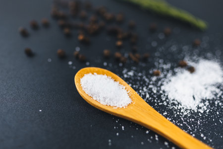 Wooden spoon with sea salt and black pepper peas. Food background.の写真素材