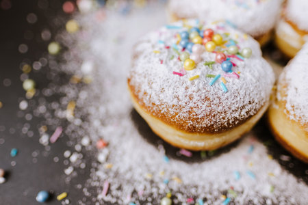 Donuts sprinkled with powdered sugar on black background.の写真素材