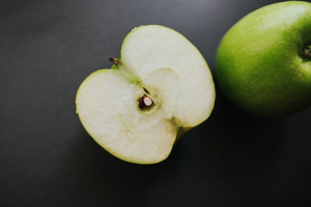 Green apple in drops of water on a black background. Design elements for poster, banner, cards.の写真素材