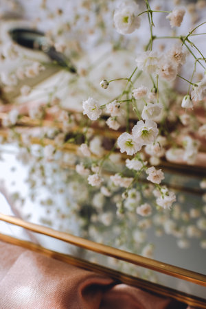 Spring composition, white gypsophila flowers with gold mirror on the gold satin fabric.の写真素材