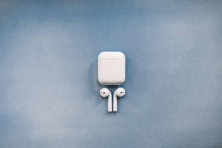 Apple AirPods wireless headphone with charging box on the color background. Use with Iphone, Ipad or...