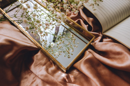 Spring composition, white gypsophila flowers with gold mirror on the gold satin fabric.の写真素材