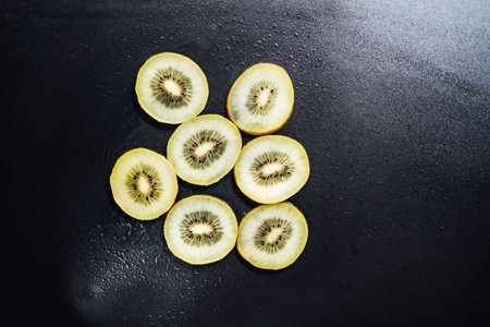Juicy kiwi fruit on a black background, top view, copy space.の写真素材
