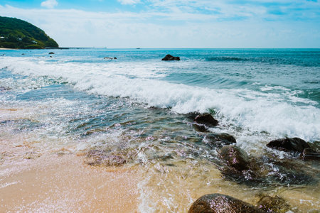 Seascape, sea wave washes a sandy beach with large stones, bright colors. High quality photoの写真素材