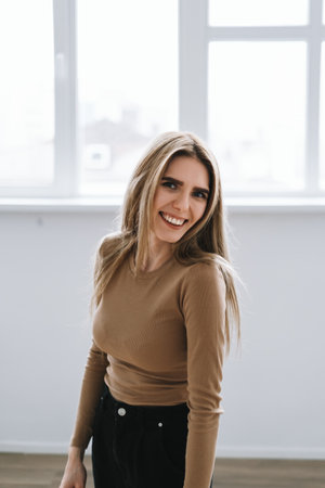 Portrait of attractive caucasian woman in bright living room with big window. High quality photoの写真素材