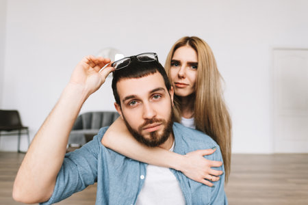 Portrait of cheerful couple sitting on the floor in new apartment. High quality photo