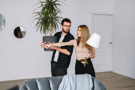 Young couple renovating their new house and moving furniture together. High quality photo