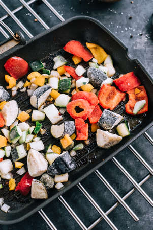Fresh vegetables mix in a black grill pan on the table. Healthy foodの写真素材