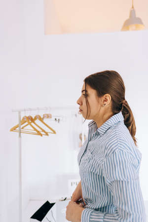 Young stylish business woman straightens her shirt, preparing for an important event. Achievement...
