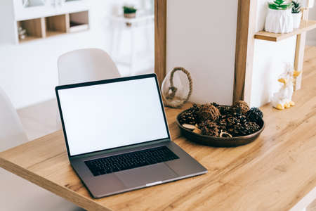 Laptop computer with white blank screen mock up, on the bright modern kitchen table.の写真素材