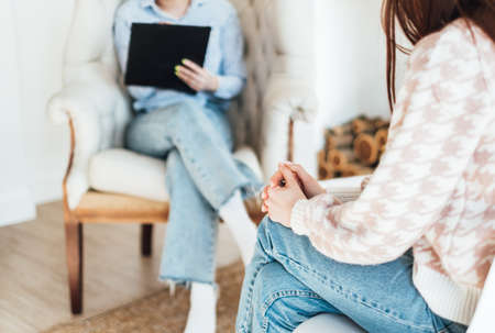 Psychotherapy session, young caucasian woman communicating with her psychologist. close-up on handsの写真素材