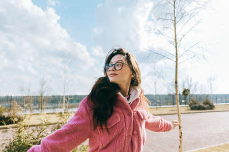 Portrait of young cheerful caucasian woman walking in the park and having fun, enjoying spring weather in sunny day.の写真素材