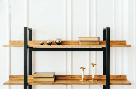 Decorative wooden shelves in living room with books and candlesticks. Modern living room interiorの写真素材