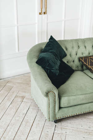 Green comfortable sofa in bright living room with minimalist interior.の写真素材