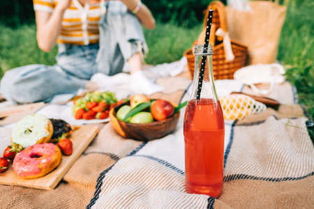 Summer drink, fresh fruits and berries, bakery on picnic blanket outdoor, summer vacation.の写真素材