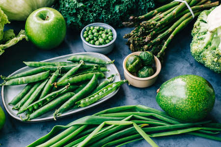 Healthy organic green food, assortment of fresh vegetables: Avocado, lettuce, broccoli, green peas, cucumber, pepper, celery, kale, asparagus and other.の写真素材