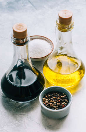 Olive oil and balsamic vinegar in bottles on the table with spices. salad sauceの写真素材