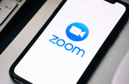 iPhone with Zoom video call app logo on the screen.のeditorial素材