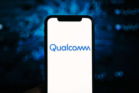 Qualcomm logo on the iPhone screen. Qualcomm is a company that manufactures processors for mobile devices.のeditorial素材