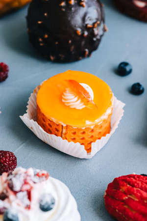 Orange dessert with biscuit, cheese filling and cream.