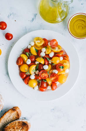 Fresh healthy salad with cherry tomatoes, mozzarella and olive oilの写真素材