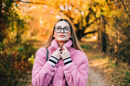 Portrait of attractive caucasian woman enjoying autumn weather in a park.の写真素材