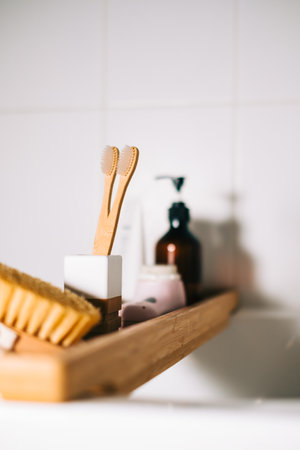 Bathroom accessories on a wooden shelf, toothbrushes, body brush and soup.の写真素材