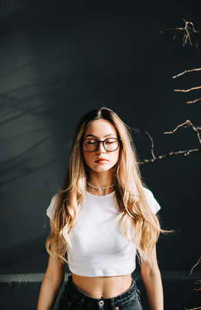 Portrait of young caucasian woman with closed eyes and blonde hair, over black background.