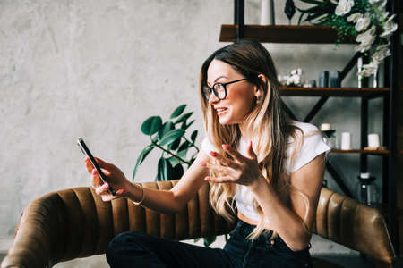 Young caucasian woman having video call, having fun and talking with friends or family.の写真素材