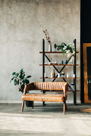 Interior of minimalist living room with shelving and brown leather couch.の写真素材