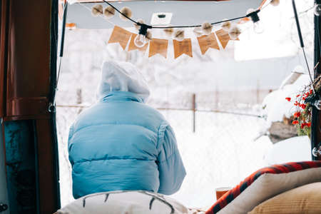 Young caucasian woman sitting in a car in winter day, during traveling on a van and enjoying holiday.の写真素材