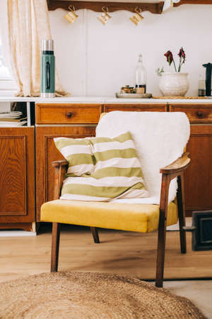 Armchair with pillow in the kitchen of countryside house, nobody.の写真素材