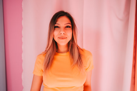Portrait of attractive caucasian cheerful woman standing over pink background.の写真素材