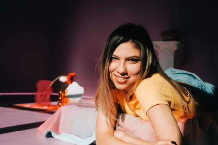 Young attractive caucasian woman relaxing on a bed in sunlight.