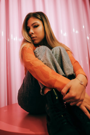 Young stylish attractive caucasian woman posing in a room with pink walls.の写真素材