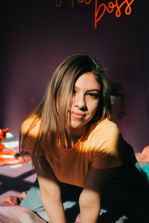 Young attractive caucasian woman relaxing on a bed in sunlight.の写真素材