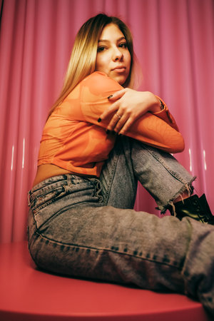 Young stylish attractive caucasian woman posing in a room with pink walls.の写真素材