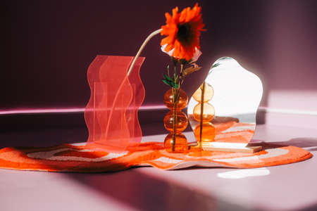 Flower on a vase and small mirror on a floor in sunlight.の写真素材