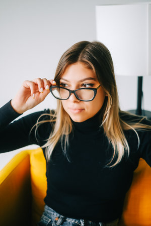 Young caucasian woman trying on glasses in a opticians store.の写真素材